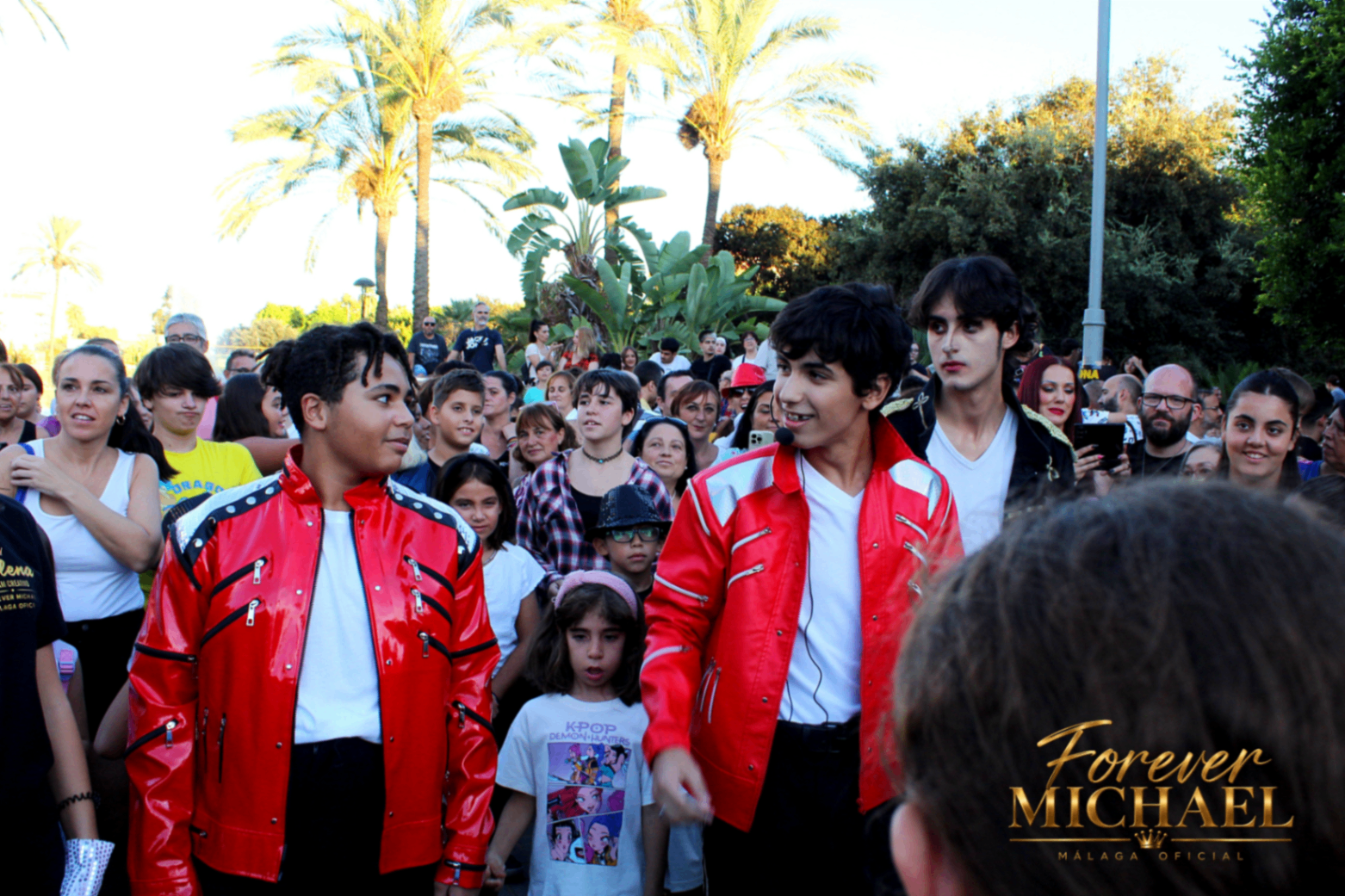 Bailarines con chaquetas rojas junto al publico