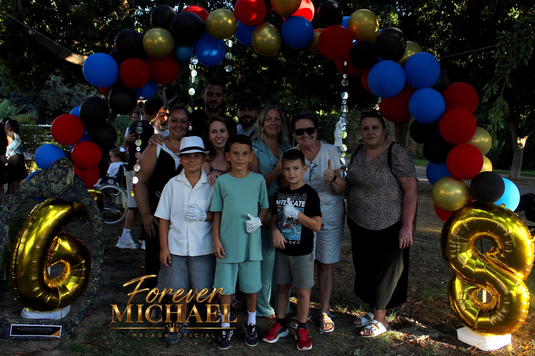 Familia y pequenos fans bajo el arco de globos